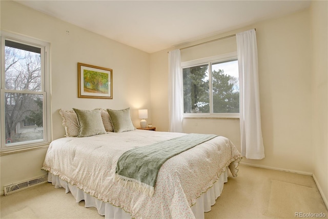 carpeted bedroom with visible vents, multiple windows, and baseboards