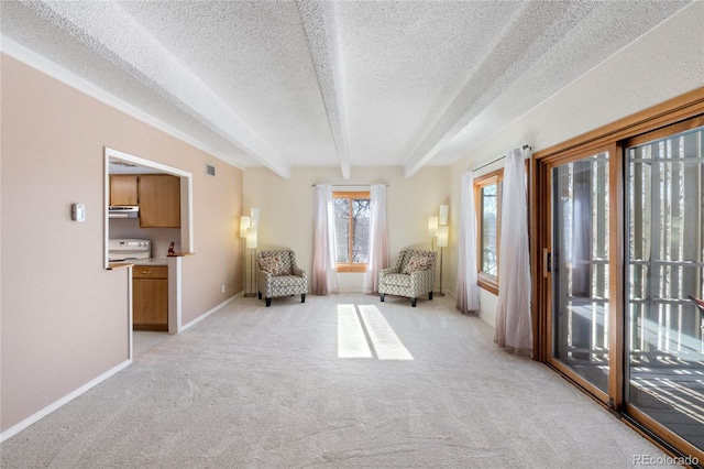 unfurnished room featuring light carpet, beamed ceiling, and a textured ceiling