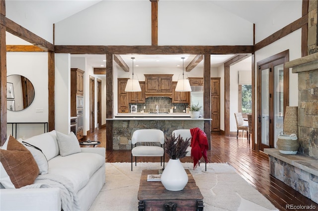 living area with high vaulted ceiling, beamed ceiling, and light wood-type flooring