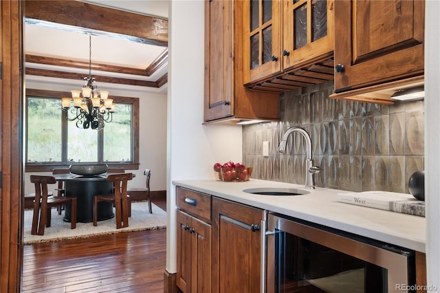 kitchen featuring a chandelier, wine cooler, decorative light fixtures, sink, and dark hardwood / wood-style floors