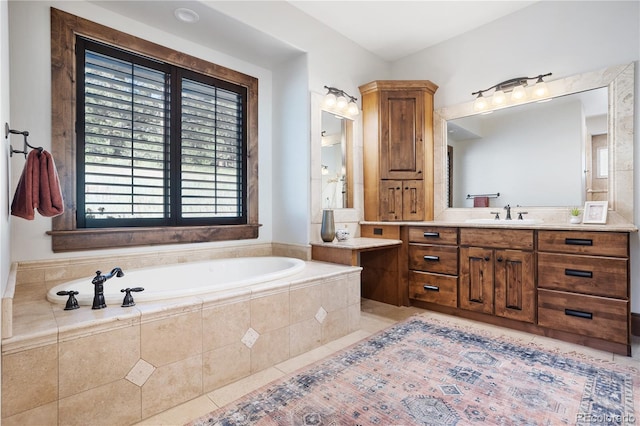 bathroom with tile patterned flooring, tiled bath, and vanity