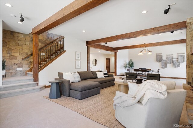 living room featuring an inviting chandelier, beamed ceiling, and light carpet