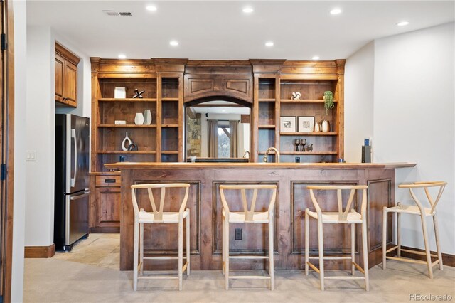 bar with light colored carpet, stainless steel refrigerator, and sink