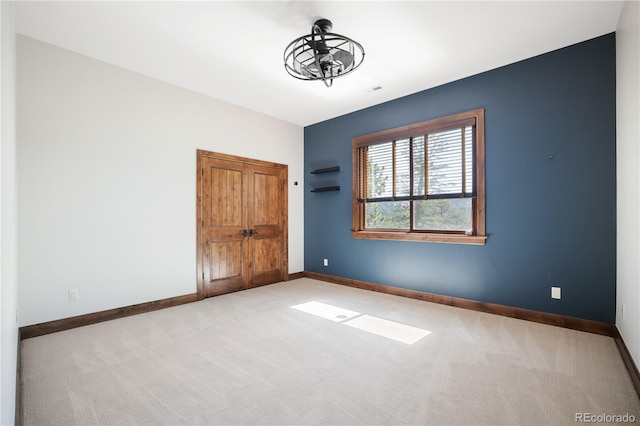 unfurnished room featuring carpet floors and baseboards