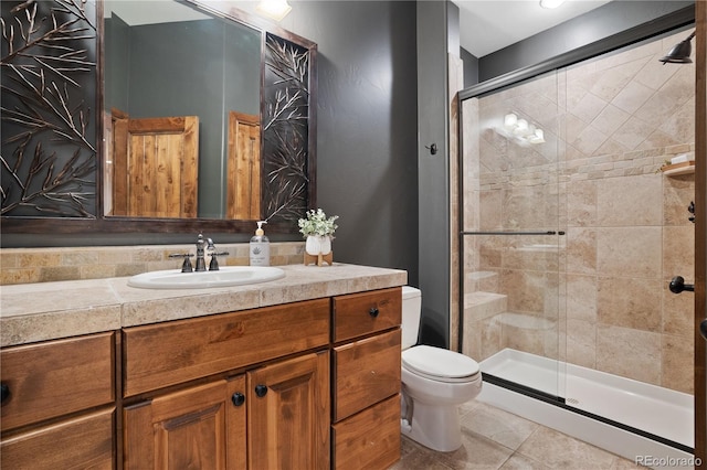 full bathroom with a stall shower, tile patterned flooring, vanity, and toilet