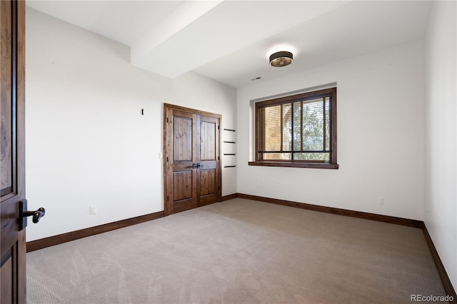 unfurnished room featuring carpet floors and baseboards