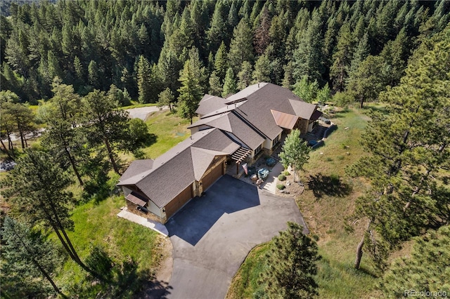 drone / aerial view featuring a wooded view