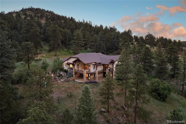 birds eye view of property featuring a forest view