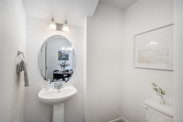 9250 Garnett Way Unit D, Arvada, CO 80007 - half bathroom featuring toilet and a chandelier