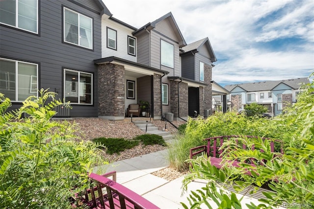 9250 Garnett Way Unit D, Arvada, CO 80007 - back of property with stone siding, covered porch, and a residential view