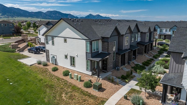 9250 Garnett Way Unit D, Arvada, CO 80007 - view of side of property with a residential view, stone siding, a mountain view, and roof with shingles