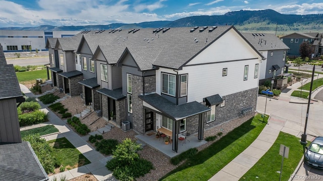 9250 Garnett Way Unit D, Arvada, CO 80007 - back of house featuring stone siding, a mountain view, a residential view, and a shingled roof