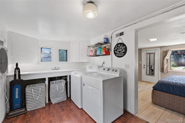 laundry room with washer and dryer, hardwood / wood-style floors, a wealth of natural light, and sink