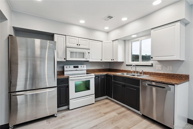 kitchen with white cabinets, light wood-type flooring, appliances with stainless steel finishes, and sink