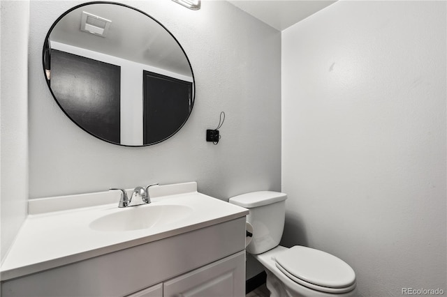 bathroom featuring toilet and vanity