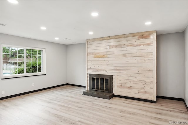 unfurnished living room featuring a large fireplace and light wood-type flooring