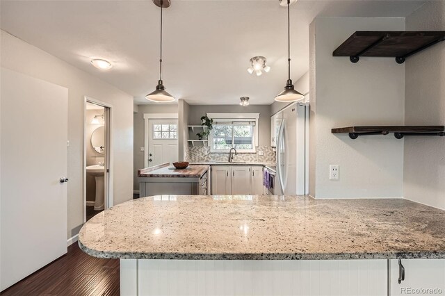 6492 Simms St Unit A, Arvada, CO 80004 - kitchen with freestanding refrigerator, dark wood finished floors, open shelves, light stone countertops, and a sink