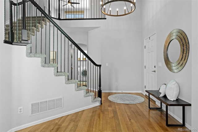 2880 Breezy Ln, Castle Rock, CO 80109 - foyer featuring a high ceiling, baseboards, wood finished floors, stairs, and a chandelier