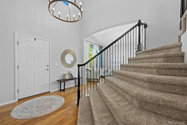 2880 Breezy Ln, Castle Rock, CO 80109 - foyer entrance featuring stairs, arched walkways, a high ceiling, wood finished floors, and baseboards