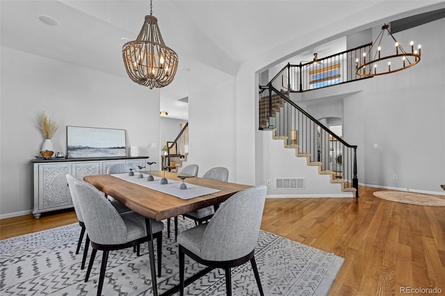 2880 Breezy Ln, Castle Rock, CO 80109 - dining space featuring a chandelier, stairway, wood finished floors, baseboards, and high vaulted ceiling