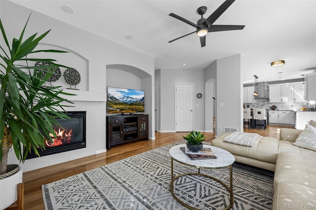 2880 Breezy Ln, Castle Rock, CO 80109 - living room with a ceiling fan, wood finished floors, a tiled fireplace, and baseboards