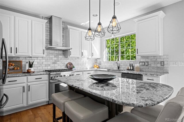 2880 Breezy Ln, Castle Rock, CO 80109 - kitchen with high end stainless steel range oven, wall chimney exhaust hood, white cabinetry, and recessed lighting