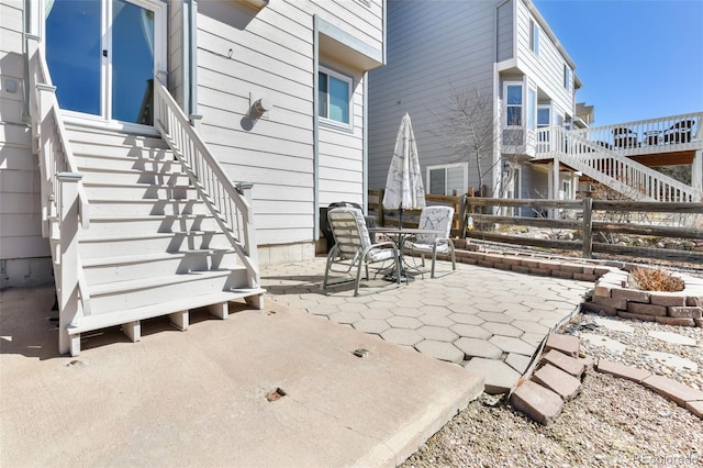 view of patio featuring stairs and fence