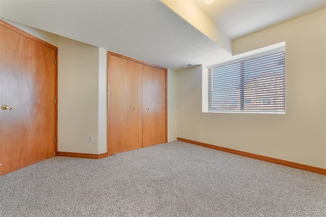 unfurnished bedroom with a closet, carpet flooring, visible vents, and baseboards