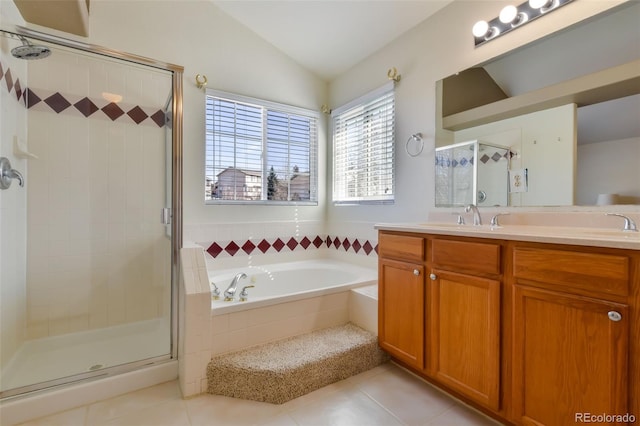 full bathroom featuring tile patterned flooring, a garden tub, lofted ceiling, a stall shower, and vanity