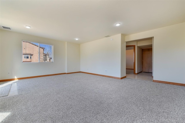 unfurnished room featuring baseboards, visible vents, and light carpet