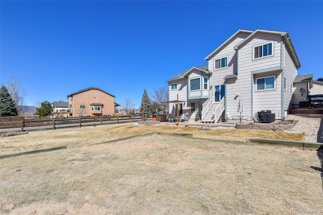 rear view of property with entry steps and fence