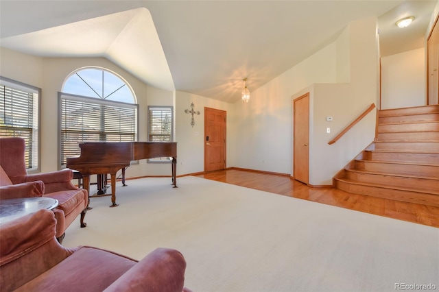 living area featuring vaulted ceiling, stairway, baseboards, and carpet floors