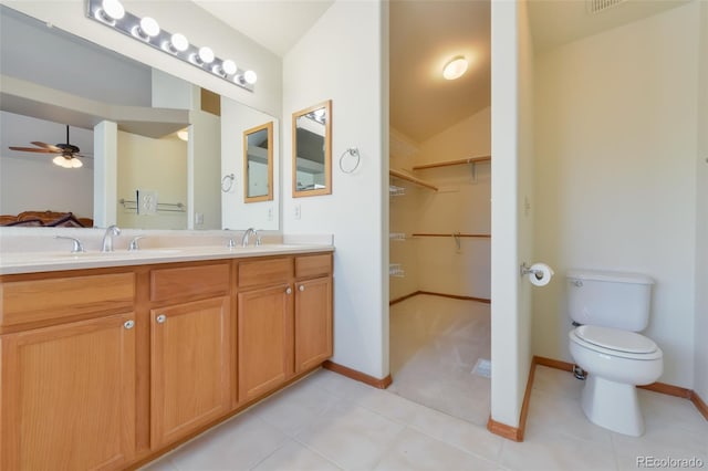 bathroom featuring double vanity, toilet, a ceiling fan, and a sink