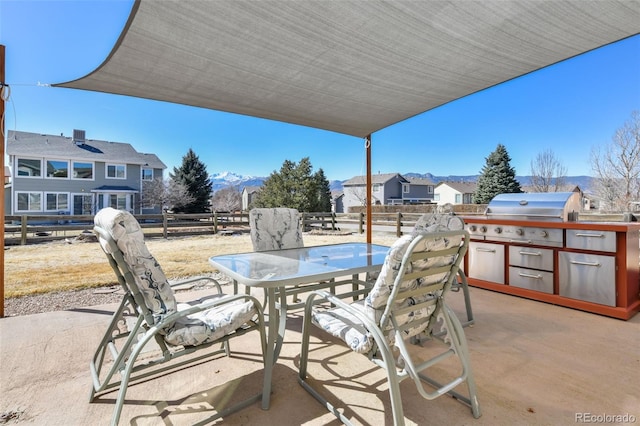 view of patio / terrace featuring outdoor dining area, fence, an outdoor kitchen, and grilling area