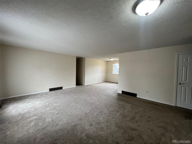 empty room featuring dark carpet and a textured ceiling