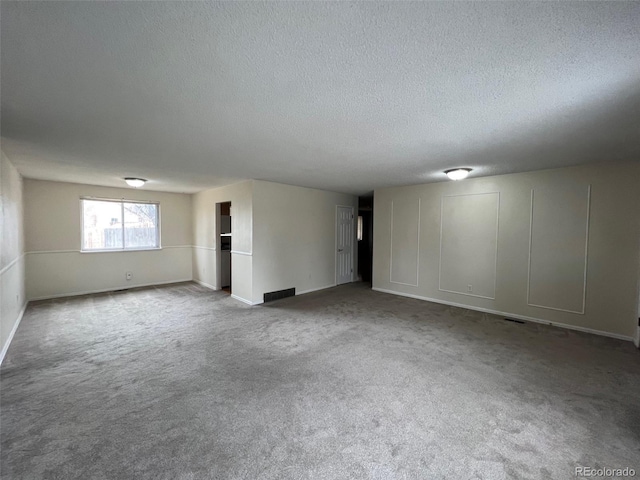 unfurnished room featuring carpet and a textured ceiling