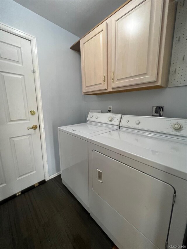 clothes washing area featuring dark wood-type flooring, cabinets, and independent washer and dryer