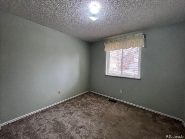 carpeted empty room featuring a textured ceiling