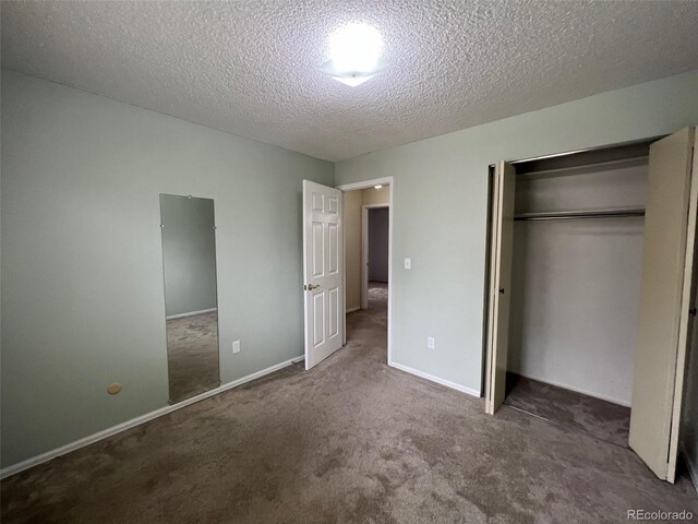 unfurnished bedroom featuring a closet, a textured ceiling, and dark colored carpet