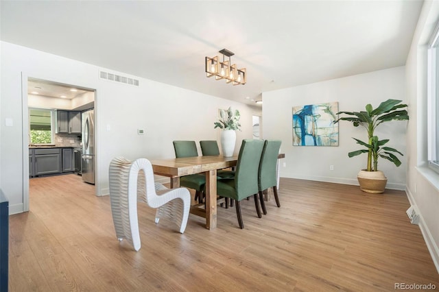 1420 W Ridge Rd, Littleton, CO 80120 - dining area with light wood-type flooring, baseboards, and a chandelier