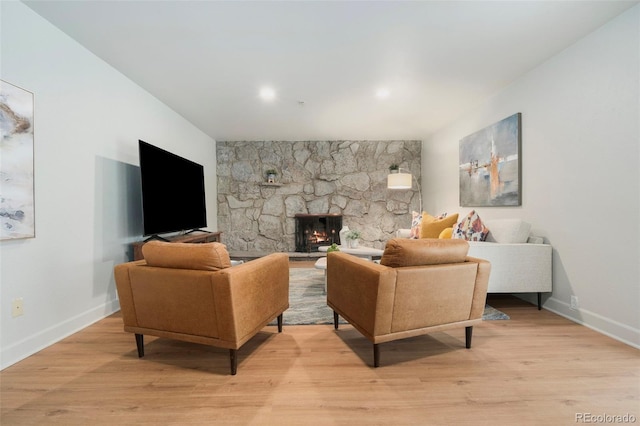 1420 W Ridge Rd, Littleton, CO 80120 - living area featuring light wood finished floors, baseboards, and a stone fireplace