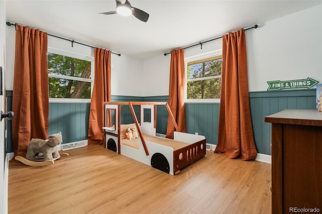1420 W Ridge Rd, Littleton, CO 80120 - bedroom with multiple windows, wood finished floors, and wainscoting