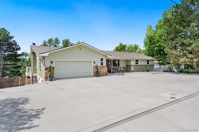 1420 W Ridge Rd, Littleton, CO 80120 - single story home featuring a garage, a chimney, driveway, stone siding, and roof with shingles