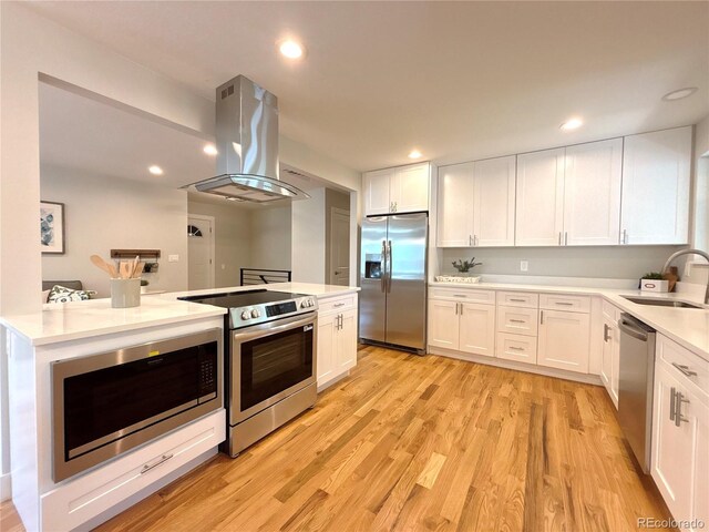 6484 S Datura St, Littleton, CO 80120 - kitchen featuring appliances with stainless steel finishes, island exhaust hood, light wood-type flooring, white cabinets, and light countertops