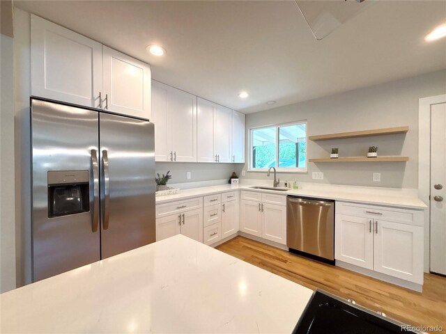 6484 S Datura St, Littleton, CO 80120 - kitchen featuring stainless steel appliances, light wood-style floors, light countertops, white cabinets, and open shelves