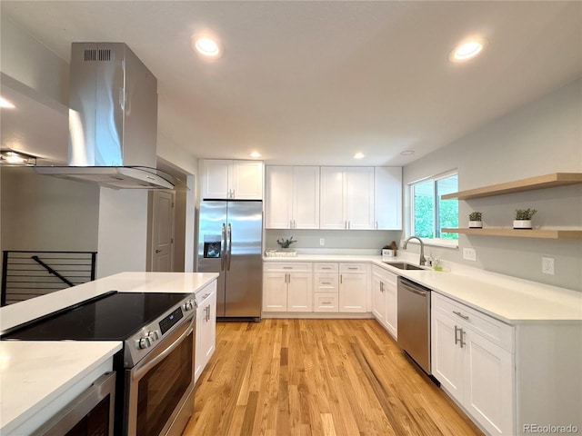 6484 S Datura St, Littleton, CO 80120 - kitchen with stainless steel appliances, island range hood, white cabinetry, light wood-style floors, and recessed lighting