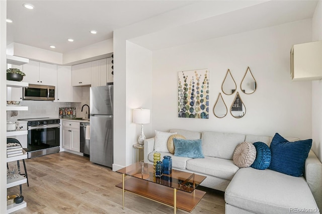living room featuring light wood finished floors and recessed lighting