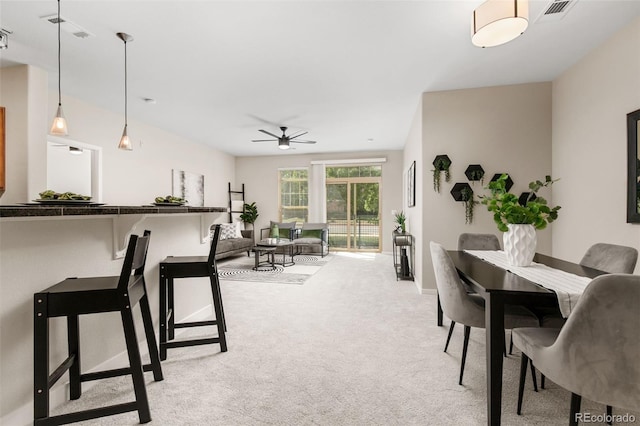 carpeted dining area with ceiling fan