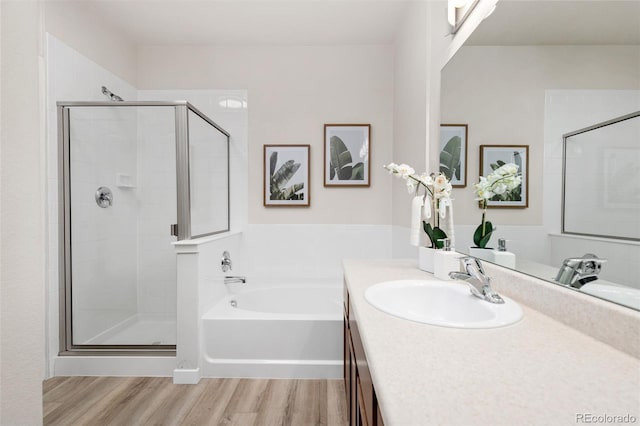 bathroom with vanity, hardwood / wood-style floors, and plus walk in shower