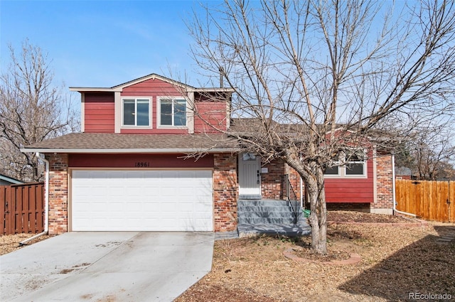 split level home with brick siding, fence, concrete driveway, roof with shingles, and a garage